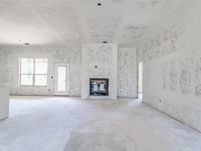 11701 Ward Rd, Edmond, OK 73034 - unfurnished living room featuring unfinished concrete flooring and a fireplace