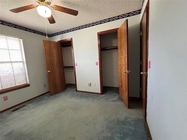 425 W Crooked Branch Way, Mustang, OK 73064 - unfurnished bedroom with a textured ceiling, two closets, carpet, and a ceiling fan