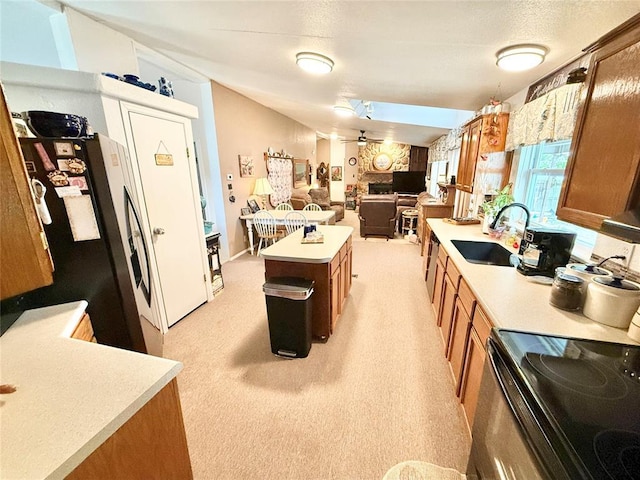 305 N Greer Ave, Duke, OK 73532 - kitchen with a sink, brown cabinets, light countertops, black electric range, and a center island