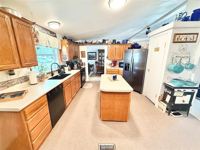 305 N Greer Ave, Duke, OK 73532 - kitchen featuring black appliances, a sink, a center island, vaulted ceiling, and light countertops