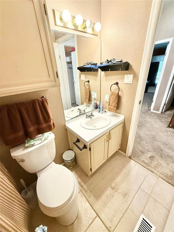 305 N Greer Ave, Duke, OK 73532 - bathroom featuring vanity, toilet, and a textured wall