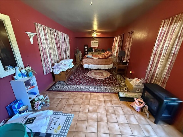 bedroom with tile patterned floors, a wood stove, and a wall mounted AC