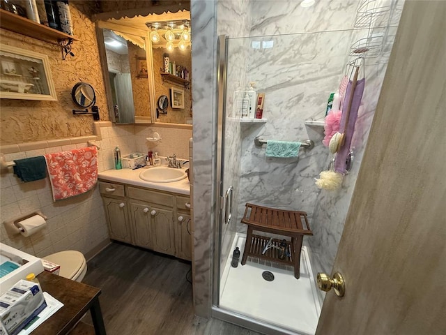 bathroom featuring tile walls, vanity, a stall shower, wood finished floors, and toilet