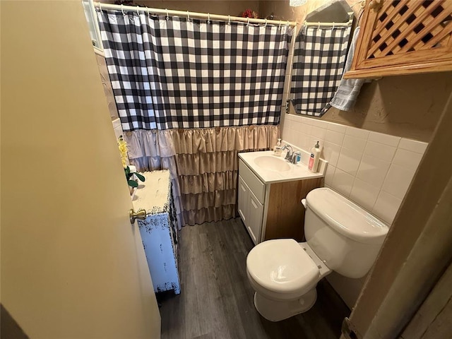 bathroom with toilet, tile walls, vanity, wood finished floors, and a shower with curtain