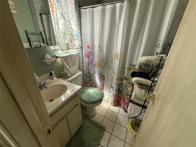 bathroom with toilet, vanity, tile patterned floors, and curtained shower