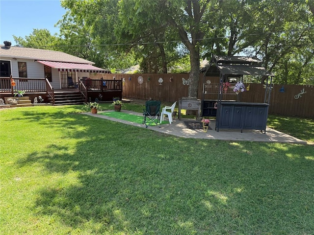 view of yard featuring a wooden deck and a patio