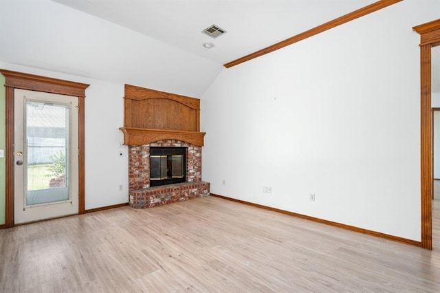 11014 Madison Ave, Midwest City, OK 73130 - unfurnished living room featuring vaulted ceiling, light wood finished floors, baseboards, and a brick fireplace