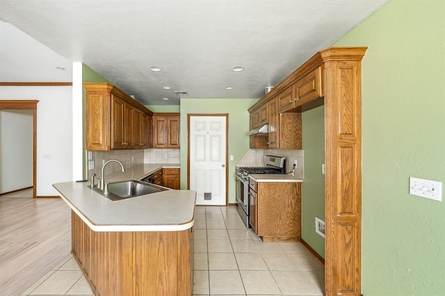 11014 Madison Ave, Midwest City, OK 73130 - kitchen with gas stove, a sink, a peninsula, tasteful backsplash, and recessed lighting