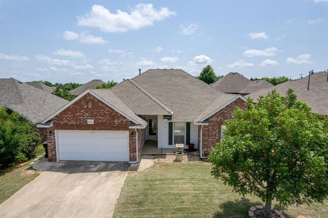 11014 Madison Ave, Midwest City, OK 73130 - view of front of home with brick siding, concrete driveway, an attached garage, and a front lawn
