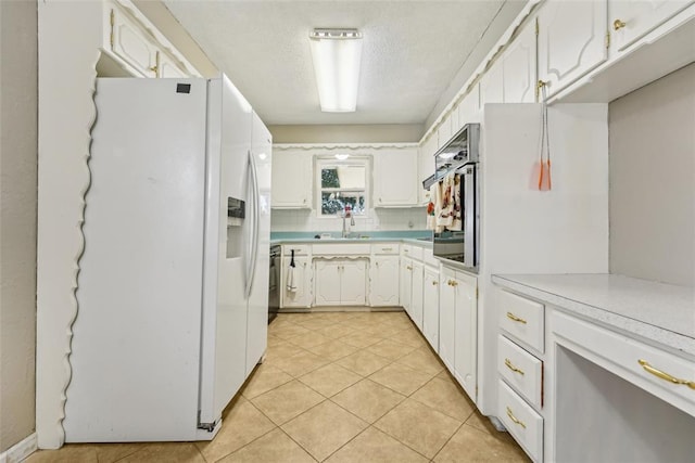 1313 SW 69th St, Oklahoma City, OK 73159 - kitchen featuring white fridge with ice dispenser, a sink, white cabinets, light countertops, and light tile patterned flooring