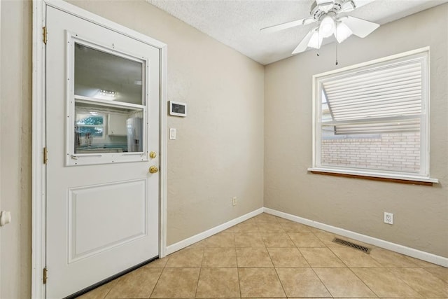 1313 SW 69th St, Oklahoma City, OK 73159 - entryway with ceiling fan, light tile patterned flooring, baseboards, plenty of natural light, and a textured ceiling