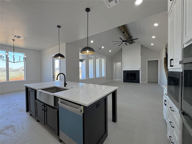 7217 NW 154th St, Edmond, OK 73013 - kitchen featuring a sink, dishwashing machine, an island with sink, a chandelier, and dark cabinetry