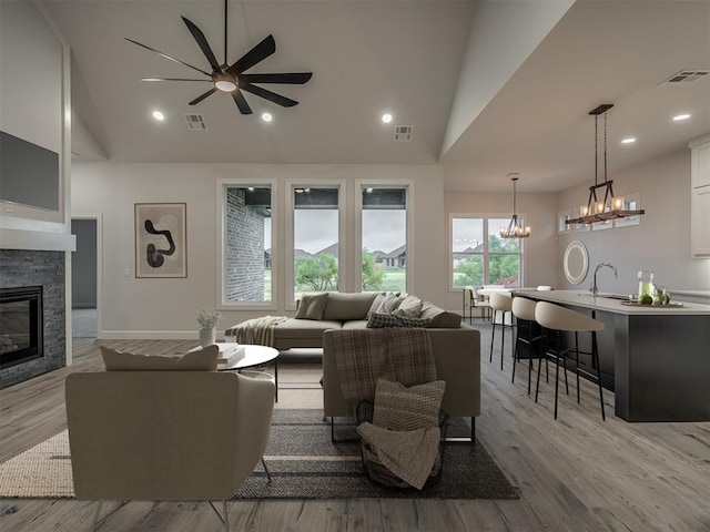 7217 NW 154th St, Edmond, OK 73013 - living room featuring a chandelier, ceiling fan, a stone fireplace, light wood finished floors, and recessed lighting