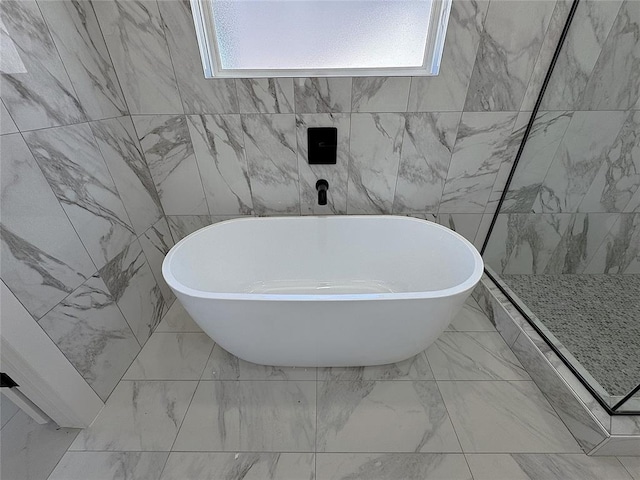7217 NW 154th St, Edmond, OK 73013 - full bathroom with healthy amount of natural light, a freestanding tub, and marble look tiles