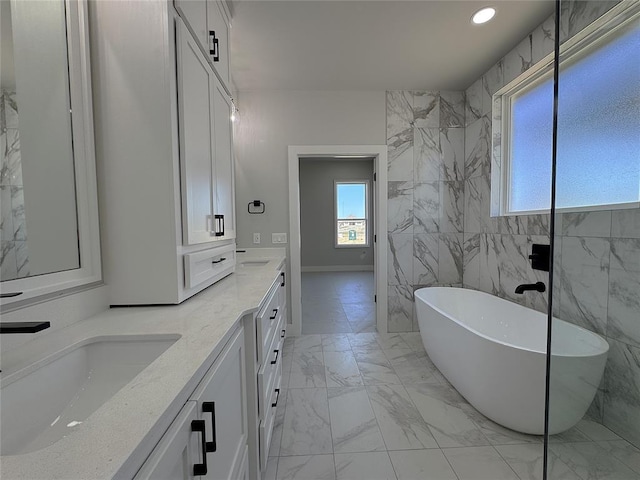 7217 NW 154th St, Edmond, OK 73013 - full bathroom with plenty of natural light, a freestanding bath, double vanity, marble finish floors, and recessed lighting