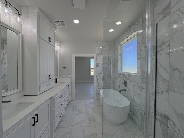 7217 NW 154th St, Edmond, OK 73013 - full bath with marble look tiles, a soaking tub, double vanity, and recessed lighting