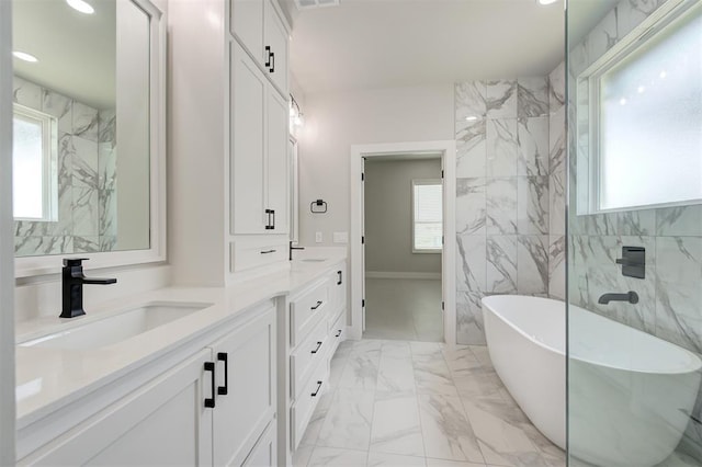 7217 NW 154th St, Edmond, OK 73013 - full bath with a soaking tub, double vanity, marble look tile flooring, recessed lighting, and tile walls