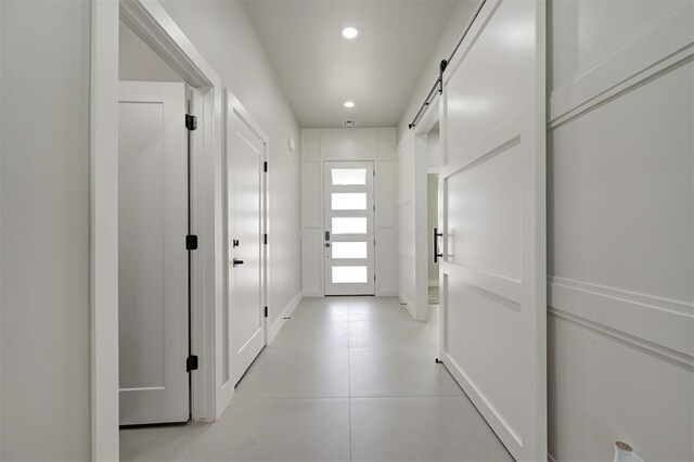 7217 NW 154th St, Edmond, OK 73013 - corridor featuring light tile patterned floors, a barn door, and recessed lighting