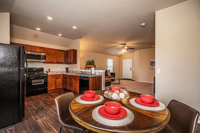 1701 Cambridge Row, The Village, OK 73120 - kitchen featuring black appliances, a peninsula, dark wood-style flooring, open floor plan, and vaulted ceiling