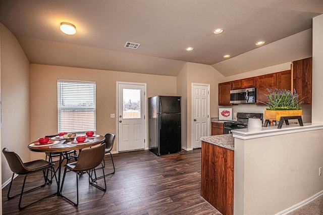 1701 Cambridge Row, The Village, OK 73120 - kitchen with freestanding refrigerator, stainless steel microwave, gas stove, vaulted ceiling, and dark wood-style floors
