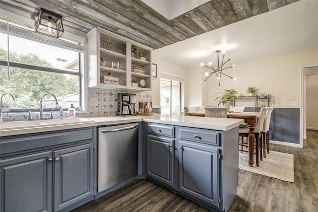 2416 Northwood Ln, Edmond, OK 73013 - kitchen with stainless steel dishwasher, a peninsula, a sink, and dark wood-style flooring