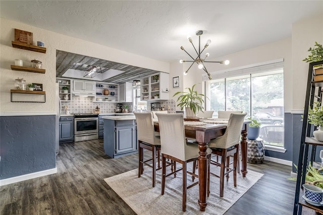 2416 Northwood Ln, Edmond, OK 73013 - dining area with a chandelier, dark wood-style flooring, baseboards, and a textured wall