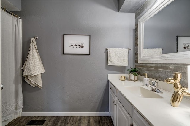 2416 Northwood Ln, Edmond, OK 73013 - bathroom with vanity, wood finished floors, and baseboards