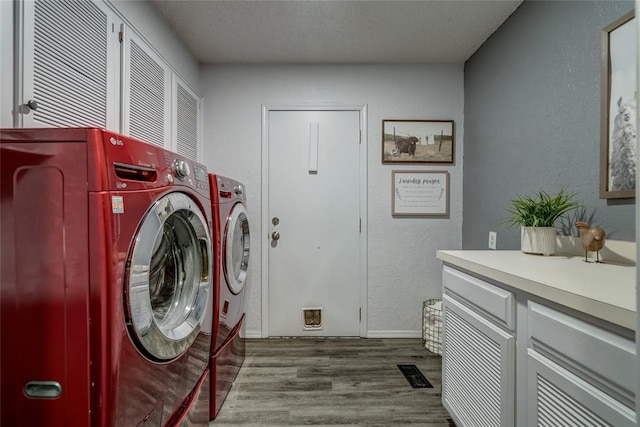 2416 Northwood Ln, Edmond, OK 73013 - laundry room featuring wood finished floors, separate washer and dryer, and a textured wall