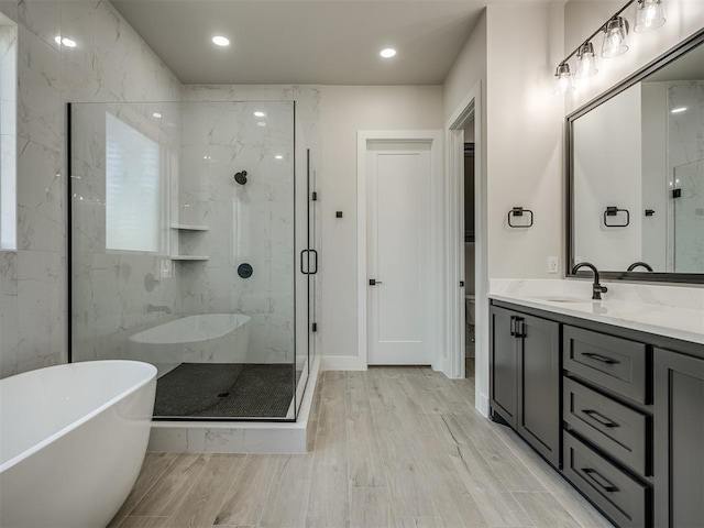 6305 NW 153rd St, Edmond, OK 73013 - full bath featuring a marble finish shower, a freestanding bath, vanity, wood finished floors, and recessed lighting
