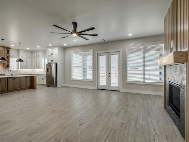 6305 NW 153rd St, Edmond, OK 73013 - unfurnished living room with a ceiling fan, a tile fireplace, recessed lighting, plenty of natural light, and light wood-type flooring