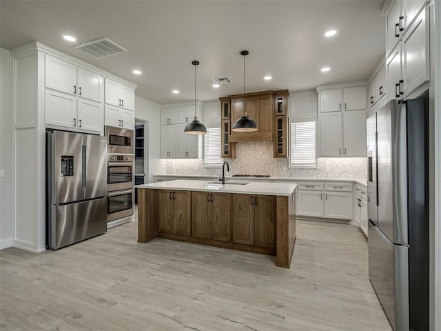 6305 NW 153rd St, Edmond, OK 73013 - kitchen with stainless steel appliances, light countertops, backsplash, glass insert cabinets, and light wood-style floors