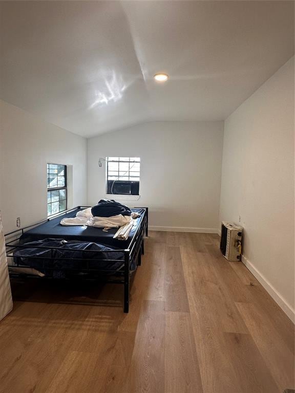 408 Wake St, Broken Bow, OK 74728 - bedroom with light wood finished floors, vaulted ceiling, and baseboards