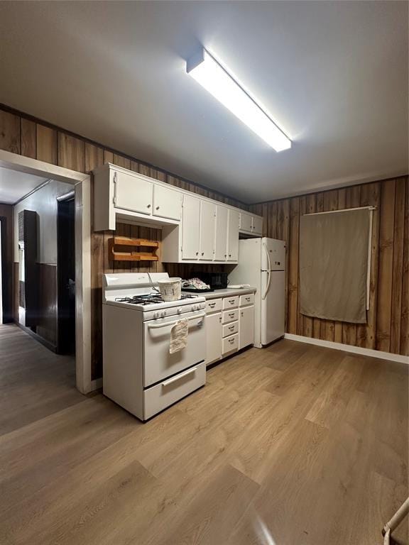 408 Wake St, Broken Bow, OK 74728 - kitchen with white appliances, light wood-type flooring, wooden walls, and white cabinets