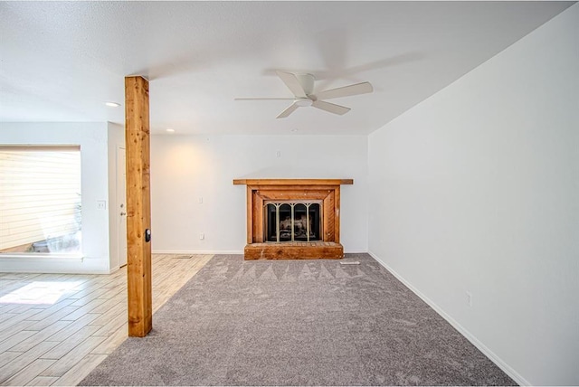 400 Timberwind Rd, Edmond, OK 73034 - unfurnished living room featuring a ceiling fan, a fireplace with raised hearth, baseboards, and carpet floors