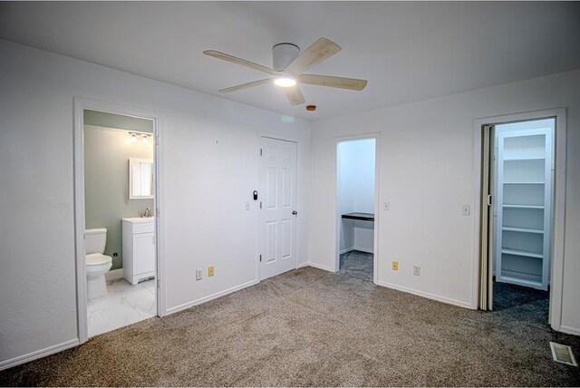 400 Timberwind Rd, Edmond, OK 73034 - unfurnished bedroom with a walk in closet, carpet, a closet, and connected bathroom