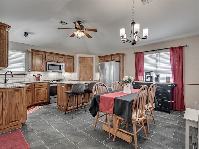 2120 NE 4th St, Moore, OK 73160 - dining area with a ceiling fan, a chandelier, and vaulted ceiling