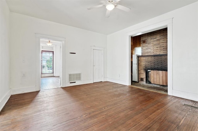 624 N Wentz St, Guthrie, OK 73044 - unfurnished living room with ceiling fan, a brick fireplace, wood finished floors, and baseboards
