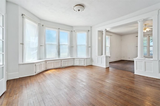 624 N Wentz St, Guthrie, OK 73044 - unfurnished room featuring decorative columns, wood-type flooring, and plenty of natural light