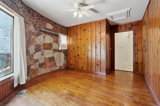 624 N Wentz St, Guthrie, OK 73044 - empty room featuring attic access, wood finished floors, wooden walls, plenty of natural light, and a ceiling fan