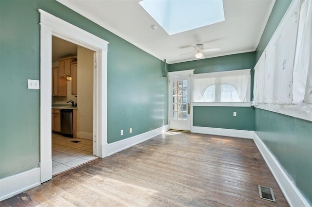 624 N Wentz St, Guthrie, OK 73044 - spare room with a skylight, crown molding, wood finished floors, ceiling fan, and baseboards