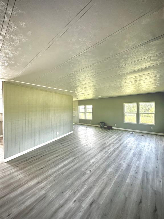 101869 S 3570th Rd, Prague, OK 74864 - unfurnished living room featuring wood finished floors and baseboards