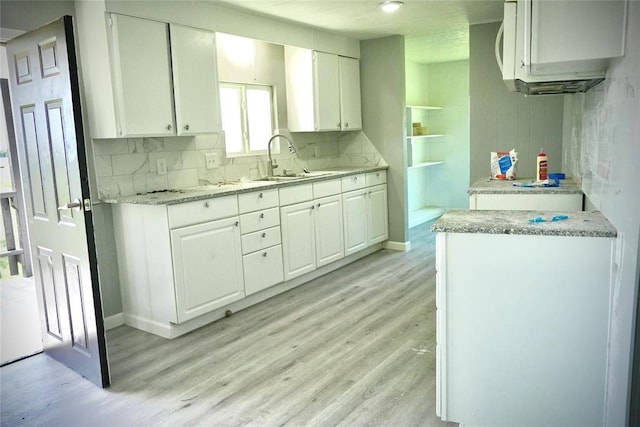 101869 S 3570th Rd, Prague, OK 74864 - kitchen with light wood-style flooring, a sink, white cabinets, and decorative backsplash