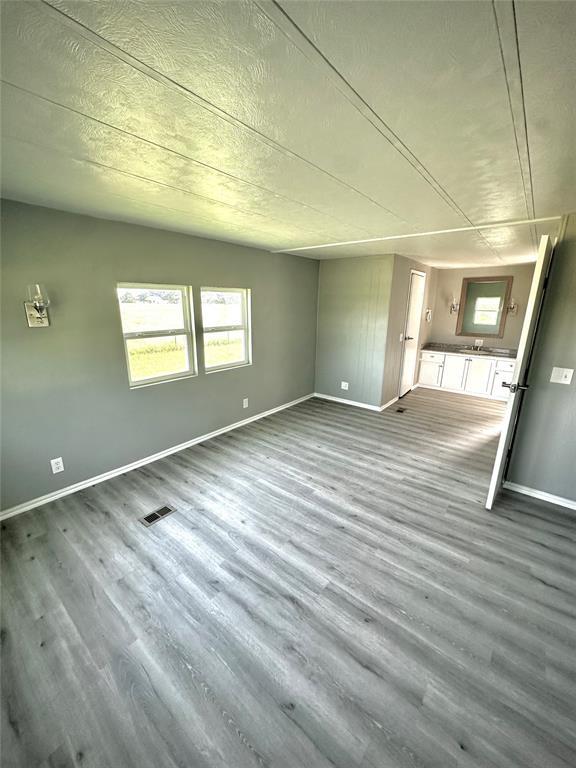 101869 S 3570th Rd, Prague, OK 74864 - unfurnished living room featuring wood finished floors and baseboards