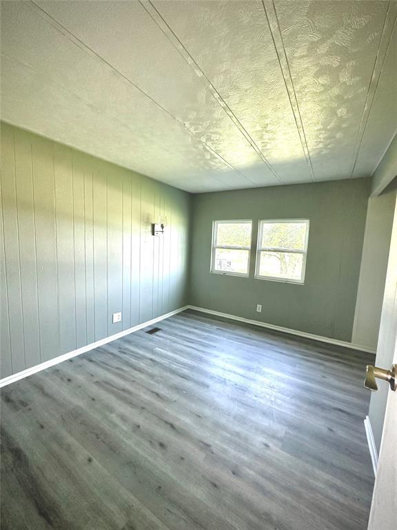 101869 S 3570th Rd, Prague, OK 74864 - unfurnished room with wood finished floors, baseboards, and a textured ceiling