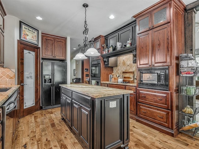 19401 N Peebly Rd, Luther, OK 73054 - kitchen featuring black appliances, tasteful backsplash, light wood finished floors, pendant lighting, and glass insert cabinets