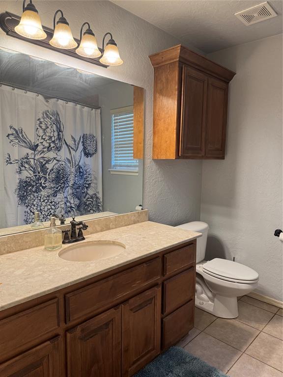 1912 SE 18th St, Moore, OK 73160 - bathroom with a textured wall, vanity, toilet, tile patterned flooring, and baseboards