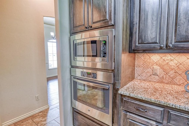5524 SE 57th St, Oklahoma City, OK 73135 - kitchen featuring stainless steel appliances, baseboards, tasteful backsplash, light stone countertops, and dark brown cabinets