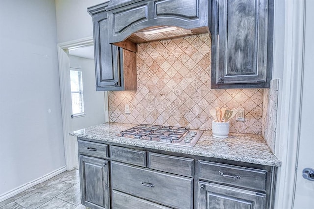 5524 SE 57th St, Oklahoma City, OK 73135 - kitchen featuring stainless steel gas cooktop, baseboards, premium range hood, decorative backsplash, and light stone countertops