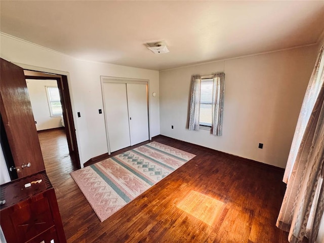 4443 Apperson Rd, Burbank, OK 74633 - unfurnished bedroom with multiple windows, wood finished floors, baseboards, and a closet