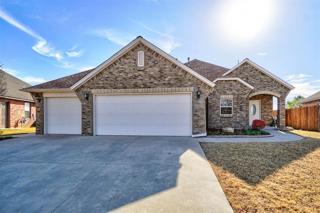 19009 Meadows Crossing Dr, Edmond, OK 73012 - view of front of home featuring concrete driveway, brick siding, a garage, and roof with shingles